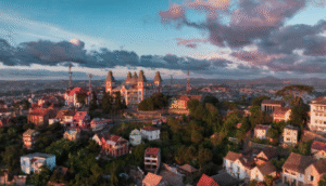 As the sun sets over Antananarivo, the city's unique architecture and lively neighborhoods are bathed in warm light, highlighting the blend of modern and traditional styles.